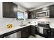 Updated kitchen featuring dark cabinets, stainless steel appliances, and a bright window at 5993 Oneida St, Commerce City, CO 80022