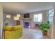 Bright living room featuring a stone fireplace, mounted TV, and comfortable seating at 17595 E Mansfield Ave # 1331L, Aurora, CO 80013