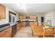Kitchen with stainless steel appliances, wooden cabinets and an adjacent wooden dining table at 2410 Morningview Ln, Castle Rock, CO 80109