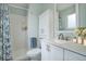 Bright bathroom featuring a shower with blue curtains, toilet and vanity at 4410 S Estes St, Littleton, CO 80123