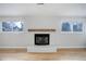 Bright living room with hardwood floors, white brick fireplace, and windows at 4410 S Estes St, Littleton, CO 80123