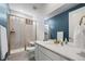 Bathroom boasts a tiled shower with gold trim, a white vanity, and a large mirror at 14651 Dahlia Way, Thornton, CO 80602