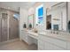 Bathroom featuring double vanity sinks, large windows, and tiled shower at 14651 Dahlia Way, Thornton, CO 80602