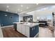 Modern kitchen features an island with white cabinets and quartz countertops, and stainless steel appliances at 14651 Dahlia Way, Thornton, CO 80602