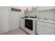 A functional laundry room equipped with modern washer, dryer, sink, and storage cabinets at 14651 Dahlia Way, Thornton, CO 80602