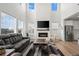 Spacious living room featuring a modern fireplace, large windows, and hardwood floors at 14651 Dahlia Way, Thornton, CO 80602
