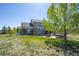 Back of the home with a patio featuring a hot tub and seating area, surrounded by a spacious yard at 8700 Ehler Pkwy, Brighton, CO 80602