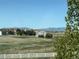 Wide shot featuring homes, mountains, and a partial view of a white fence at 8700 Ehler Pkwy, Brighton, CO 80602