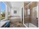 Bright bathroom featuring a soaking tub, glass-enclosed shower, and natural light at 8700 Ehler Pkwy, Brighton, CO 80602