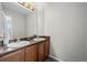 Bathroom with a double vanity, wooden cabinets, and a large mirror at 8700 Ehler Pkwy, Brighton, CO 80602