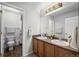 Bright bathroom featuring a double vanity, mirror, and a separate toilet and shower area at 8700 Ehler Pkwy, Brighton, CO 80602