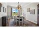 Elegant dining room featuring a farmhouse table, designer lighting, and a scenic window view at 8700 Ehler Pkwy, Brighton, CO 80602