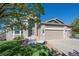 Charming two-story home featuring a three-car garage and stone accents, set against a clear blue sky at 8700 Ehler Pkwy, Brighton, CO 80602