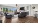Bright, open living room featuring a fireplace, built-in shelving, and hardwood floors at 8700 Ehler Pkwy, Brighton, CO 80602