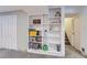 Basement hallway with bookshelf, displaying books and art, leading to a staircase at 12189 N Boot Hill Dr, Parker, CO 80138