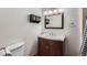 Bathroom featuring wood vanity, vanity mirror, accent lights, and dark storage baskets at 12189 N Boot Hill Dr, Parker, CO 80138