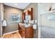Bathroom features a wood vanity with granite counters, wood floors, and a peek at the adjacent bedroom at 12189 N Boot Hill Dr, Parker, CO 80138