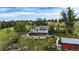 Aerial view of home with large deck, red outbuilding, partially fenced back yard with lush green grass and trees at 12189 N Boot Hill Dr, Parker, CO 80138
