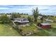 Aerial view of home featuring a large deck, red outbuilding, a partially fenced in back yard with green grass and trees at 12189 N Boot Hill Dr, Parker, CO 80138