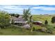 Aerial view of home with a large deck, red outbuilding, partially fenced back yard and large green space surrounding the property at 12189 N Boot Hill Dr, Parker, CO 80138