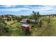 Aerial view of home with covered patio, red outbuilding, large lot, partially fenced with trees and lush green grass at 12189 N Boot Hill Dr, Parker, CO 80138