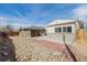 Fenced backyard with two buildings, a brick house and a garage with rock landscaping at 396 Tucson St, Aurora, CO 80011
