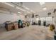 Spacious garage featuring concrete flooring, built in cabinets, and multiple windows at 396 Tucson St, Aurora, CO 80011