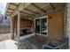 Covered patio featuring a swing bench, brick wall, and sliding glass door at 396 Tucson St, Aurora, CO 80011