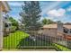 View of the community backyard from the balcony features lush green grass and mature trees at 13782 E Lehigh Ave # H, Aurora, CO 80014