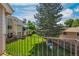 Balcony view of grassy backyard with privacy fence, mature tree, and neighboring townhomes in daylight at 13782 E Lehigh Ave # H, Aurora, CO 80014