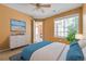 Comfortable bedroom with a white dresser, a television with beach images, and a bright window at 13782 E Lehigh Ave # H, Aurora, CO 80014
