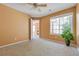 Cozy bedroom features neutral carpet, a ceiling fan, and a large window overlooking the community at 13782 E Lehigh Ave # H, Aurora, CO 80014