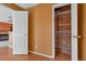 Hallway with an open closet and entryway leading to the living room and fireplace at 13782 E Lehigh Ave # H, Aurora, CO 80014