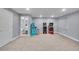 Basement with a few arcade games, a stool, and a view to the bathroom; gray walls and light colored carpet at 6591 N Ceylon St, Denver, CO 80249