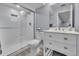 Bathroom features a glass door shower with a niche, and a white vanity with ample storage at 6591 N Ceylon St, Denver, CO 80249
