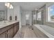 Luxurious bathroom with double vanity, soaking tub, and tiled walk-in shower at 6591 N Ceylon St, Denver, CO 80249