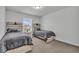 This bedroom features two beds with matching gray comforters, as well as matching end tables and natural light at 6591 N Ceylon St, Denver, CO 80249