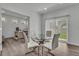 Bright dining area with glass table, white chairs, and view to the outdoor landscape at 6591 N Ceylon St, Denver, CO 80249