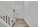 Bright entryway featuring a staircase, carpeted steps, wood floors and white walls with a coatrack at 6591 N Ceylon St, Denver, CO 80249
