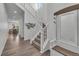 Bright entryway with a staircase, stylish decor, wood floors and a built-in bench with coat hooks at 6591 N Ceylon St, Denver, CO 80249