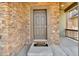Closeup of the front door with a stone facade and a 'Hello Goodbye' welcome mat at 6591 N Ceylon St, Denver, CO 80249