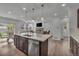 Open-concept kitchen featuring an island with pendant lighting, stainless steel appliances, and a view into the living space at 6591 N Ceylon St, Denver, CO 80249