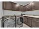 Laundry room with newer Samsung washer and dryer, overhead cabinets, and a utility sink at 6591 N Ceylon St, Denver, CO 80249