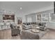 Open-concept living room features a modern design, wood floors, and bright windows at 6591 N Ceylon St, Denver, CO 80249