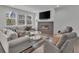 Bright living room with modern gas fireplace, large TV, and neutral color palette at 6591 N Ceylon St, Denver, CO 80249