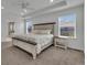 Sunlit main bedroom features a large bed, tray ceiling, and ample natural light through windows at 6591 N Ceylon St, Denver, CO 80249