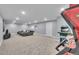 Large rec room with couch, arcade machine, and neutral tones, creating a versatile space for entertainment at 6591 N Ceylon St, Denver, CO 80249