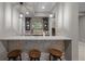 Elegant bar area with stone base, white countertop, and decorative backsplash at 7912 Raphael Ln, Littleton, CO 80125