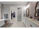 Bright bathroom with double vanity, tile accent wall, and a view into the walk-in closet at 7912 Raphael Ln, Littleton, CO 80125
