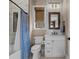 Bright bathroom with a wood framed mirror, a shower with a curtain, and vanity storage at 7912 Raphael Ln, Littleton, CO 80125